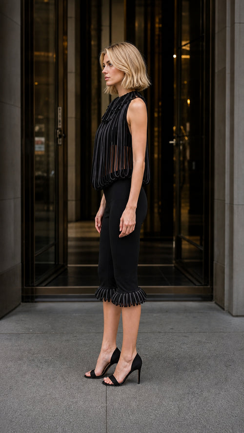 Side profile of model wearing black pleated fringe two-piece set