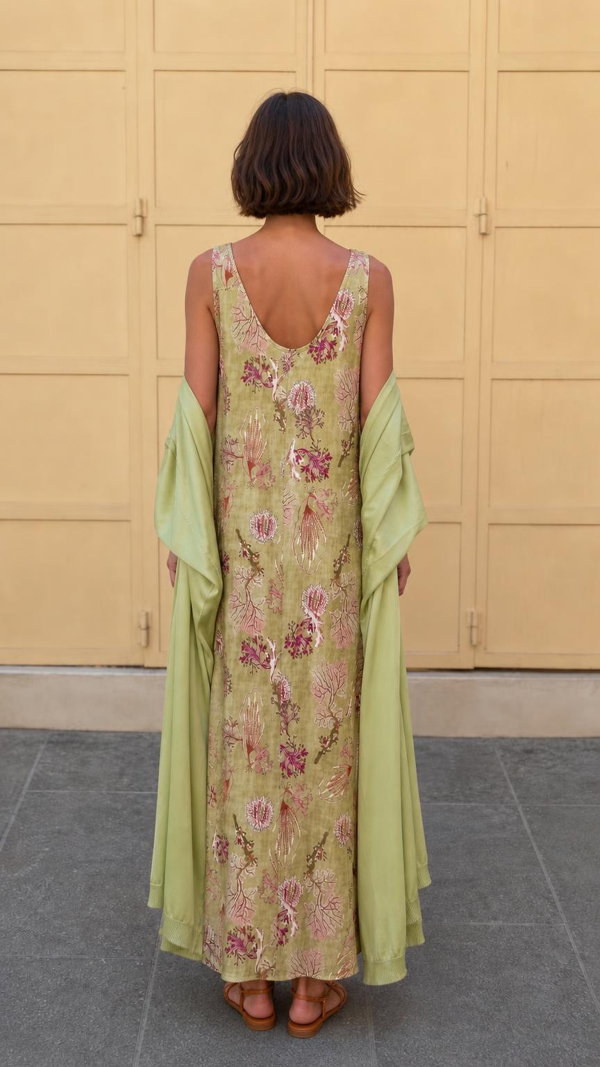 Back view of model wearing olive floral maxi dress and wrap